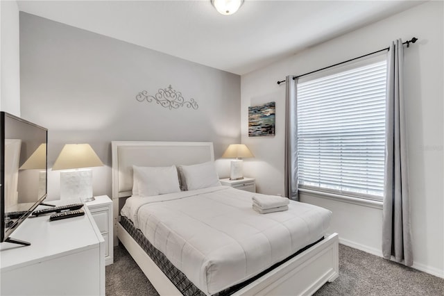 bedroom with light colored carpet, baseboards, and multiple windows