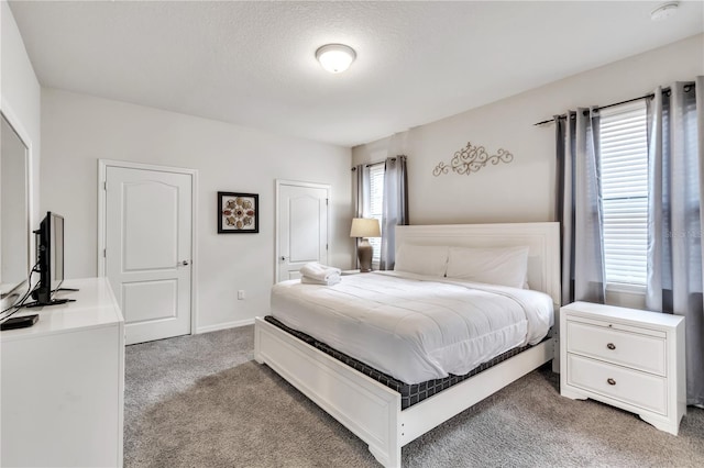 bedroom with baseboards and light colored carpet