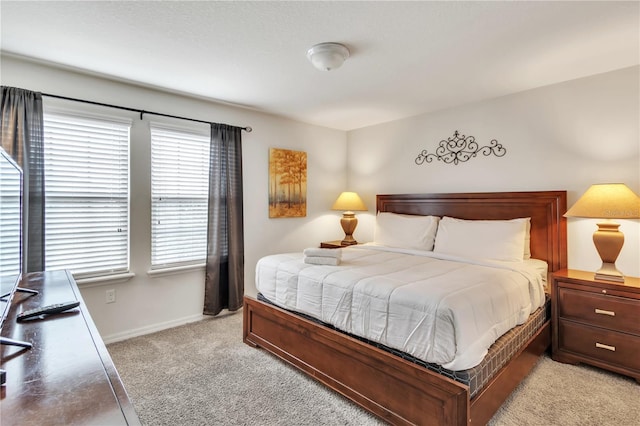 bedroom with light carpet and baseboards