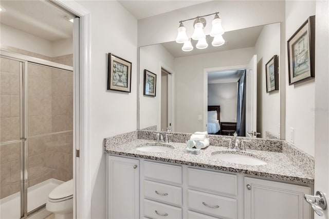 bathroom featuring double sink vanity, toilet, and an enclosed shower