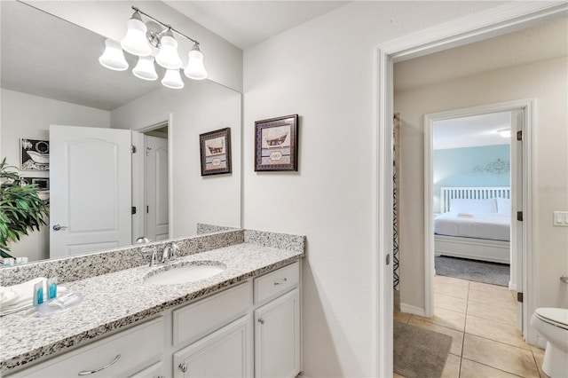 full bathroom with toilet, ensuite bathroom, vanity, baseboards, and tile patterned floors