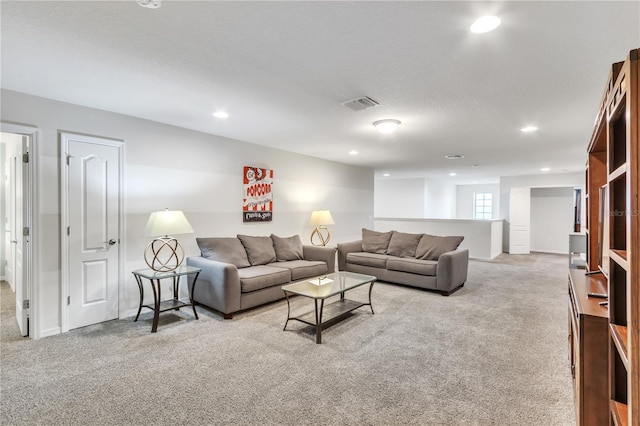 carpeted living room featuring recessed lighting, visible vents, and a textured ceiling