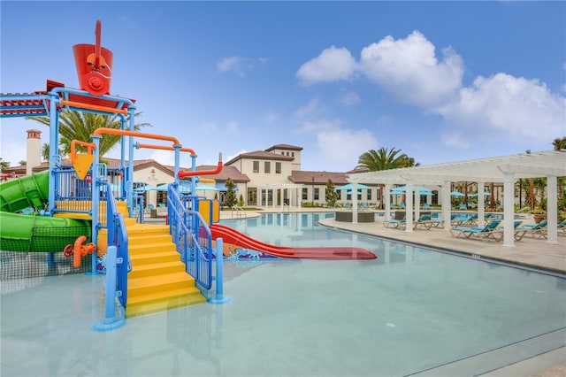 pool featuring a patio area, a water slide, a water play area, and a pergola