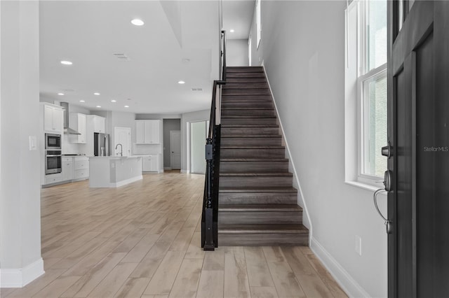 entryway with sink and light hardwood / wood-style flooring