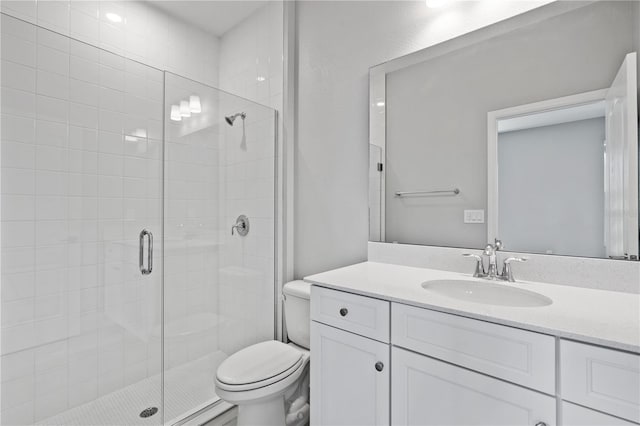 bathroom featuring vanity, toilet, and a shower with shower door