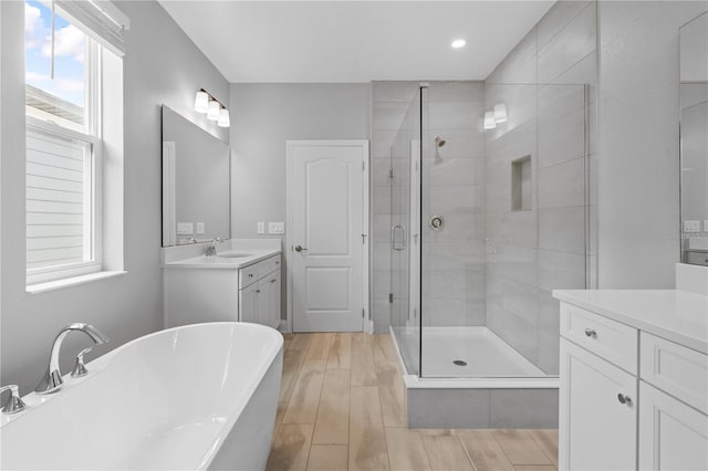 bathroom featuring vanity and independent shower and bath