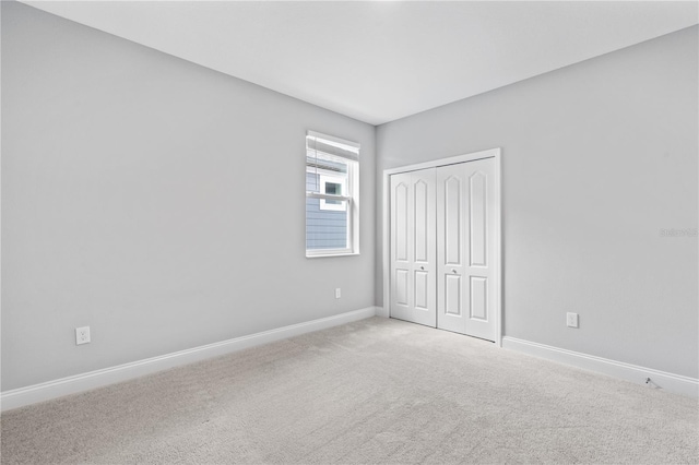 unfurnished bedroom with a closet and light carpet