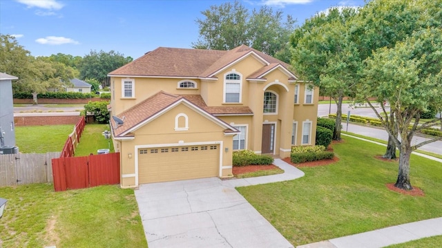 view of front of house featuring a garage, fence, driveway, stucco siding, and a front lawn