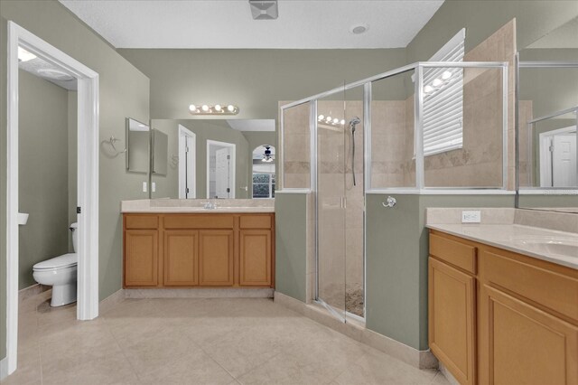 bathroom featuring vanity, tile patterned floors, toilet, and an enclosed shower