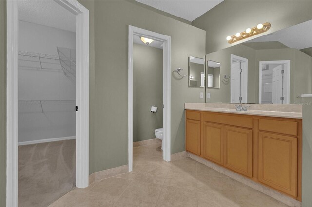 bathroom featuring tile patterned flooring, toilet, and vanity