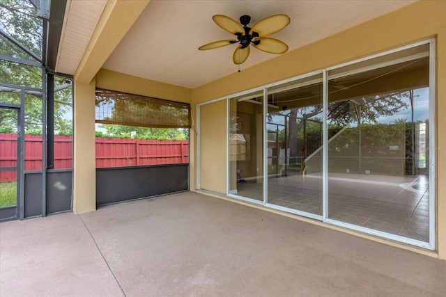 unfurnished sunroom with ceiling fan