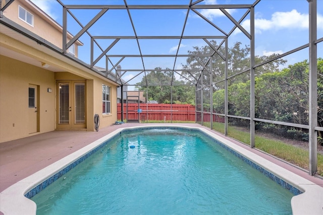 view of pool with a lanai, fence, french doors, and a patio