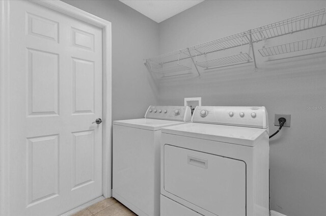 laundry room with light tile patterned flooring and independent washer and dryer