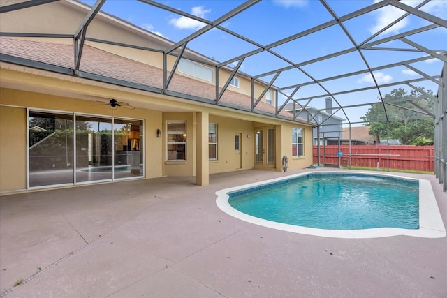 view of pool featuring a patio, glass enclosure, and ceiling fan