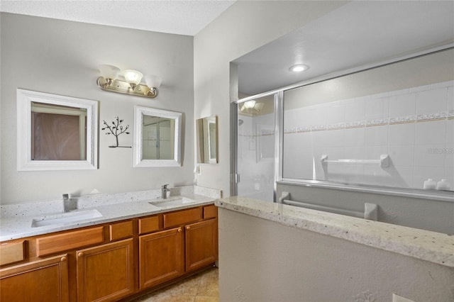 bathroom featuring vanity, tile patterned floors, a textured ceiling, and walk in shower