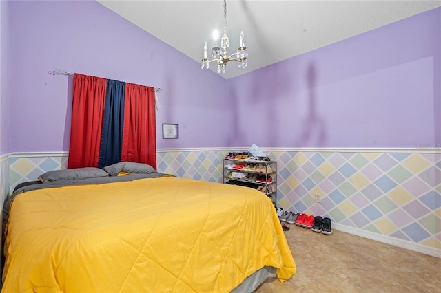 bedroom featuring a wainscoted wall, vaulted ceiling, and an inviting chandelier