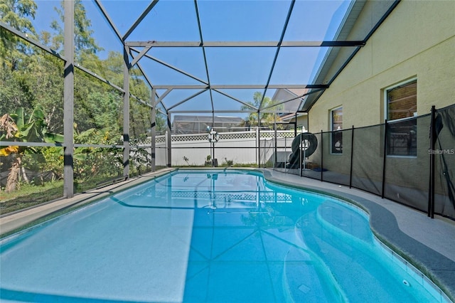 view of swimming pool featuring a fenced in pool, a patio area, and glass enclosure