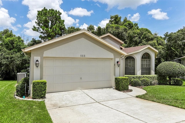 view of front of house featuring a garage, cooling unit, and a front lawn