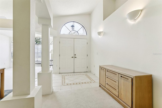 entryway featuring light tile patterned floors and a towering ceiling