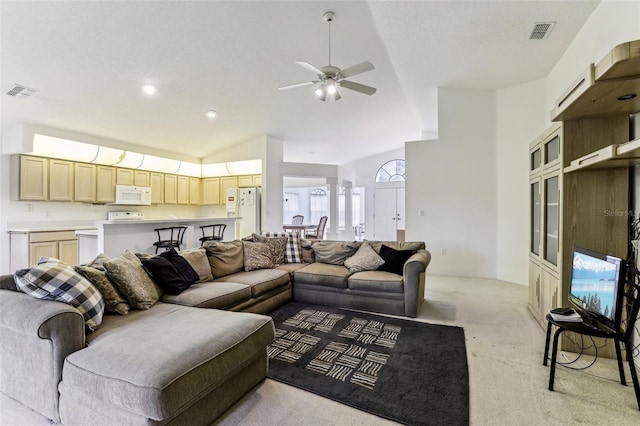 living room featuring ornate columns, ceiling fan, light colored carpet, and high vaulted ceiling