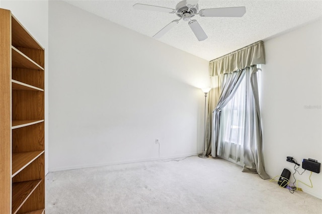 carpeted spare room featuring ceiling fan and a textured ceiling