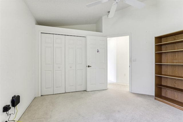 unfurnished bedroom featuring vaulted ceiling, light carpet, ceiling fan, and a closet