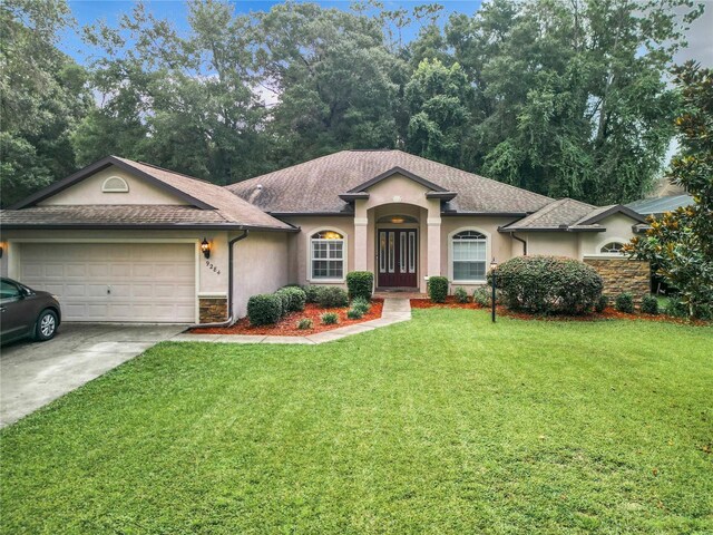 ranch-style home with a garage and a front yard