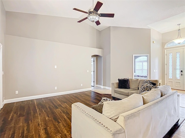 living room featuring dark wood-type flooring, high vaulted ceiling, and ceiling fan