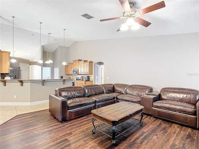 living room featuring high vaulted ceiling, ceiling fan, and wood-type flooring