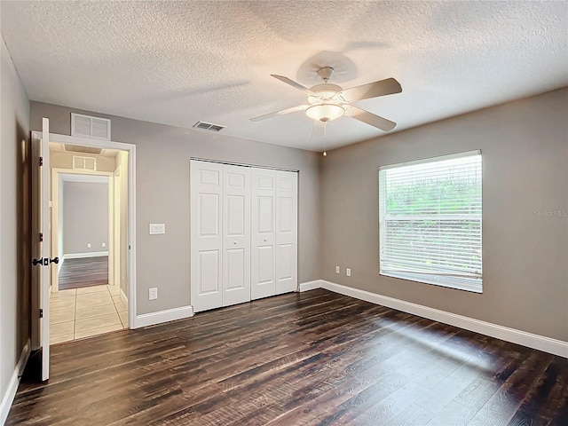 unfurnished bedroom with a closet, a textured ceiling, ceiling fan, and tile patterned flooring