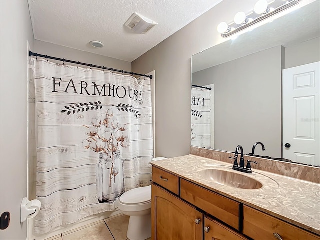 bathroom with tile patterned flooring, toilet, vanity, and a textured ceiling