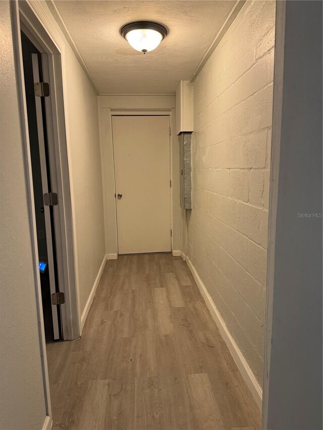 hall with a textured ceiling and hardwood / wood-style floors