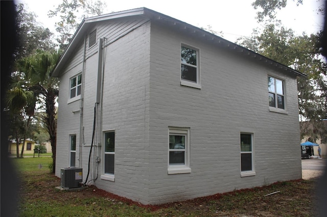 view of home's exterior with central air condition unit and brick siding