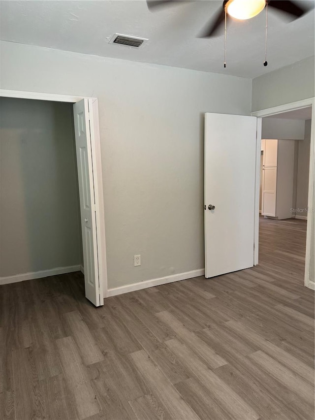 unfurnished bedroom featuring visible vents, baseboards, and wood finished floors