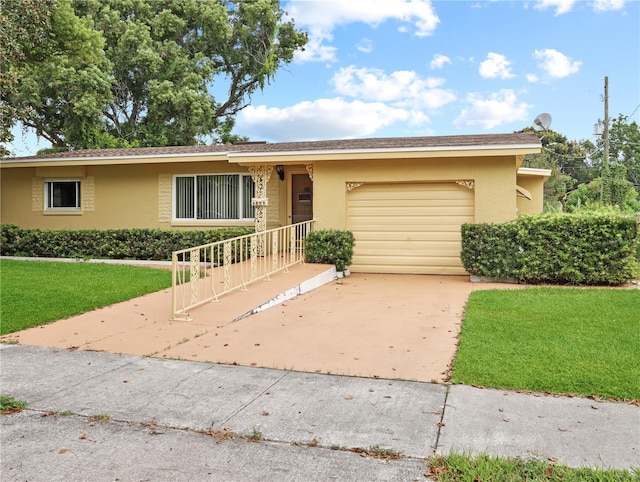 single story home with a garage, driveway, a front yard, and stucco siding