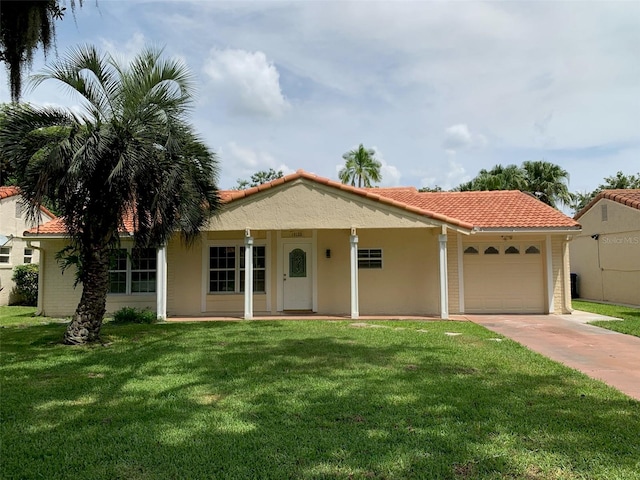 mediterranean / spanish house featuring a garage and a front yard