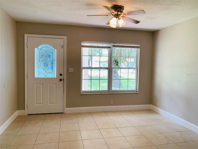 tiled foyer featuring a textured ceiling and ceiling fan