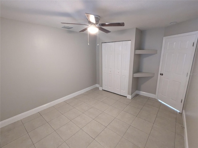 unfurnished bedroom with a closet, ceiling fan, and light tile patterned floors