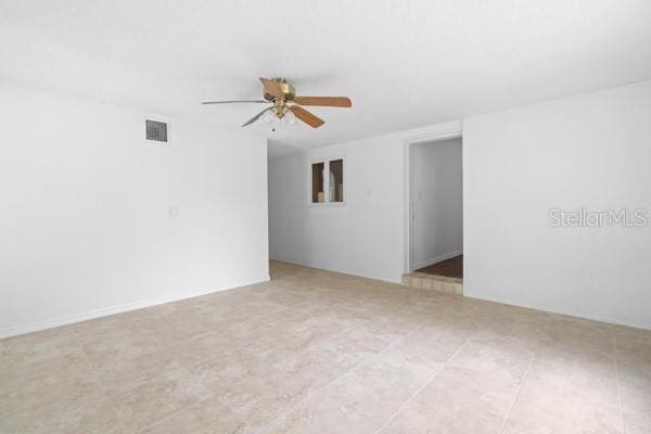 unfurnished room with visible vents and ceiling fan