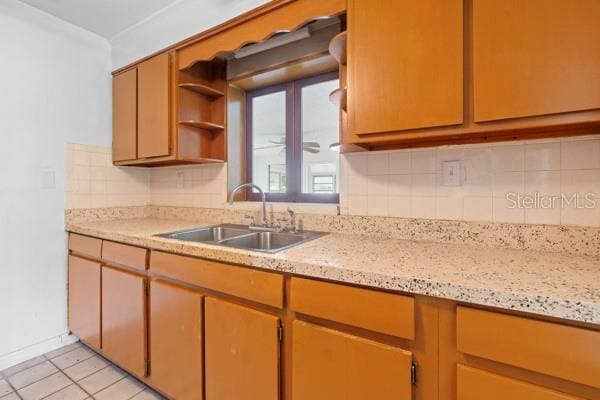 kitchen featuring a sink, open shelves, tasteful backsplash, and light tile patterned flooring