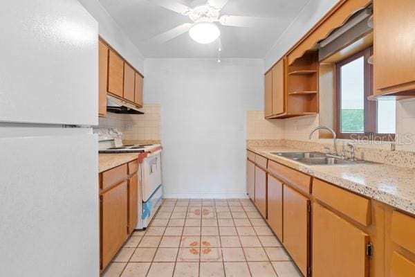 kitchen with a sink, under cabinet range hood, light countertops, white appliances, and open shelves