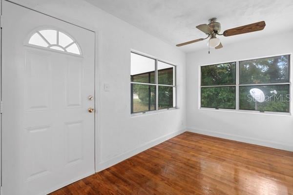 entryway featuring baseboards, wood finished floors, and a ceiling fan