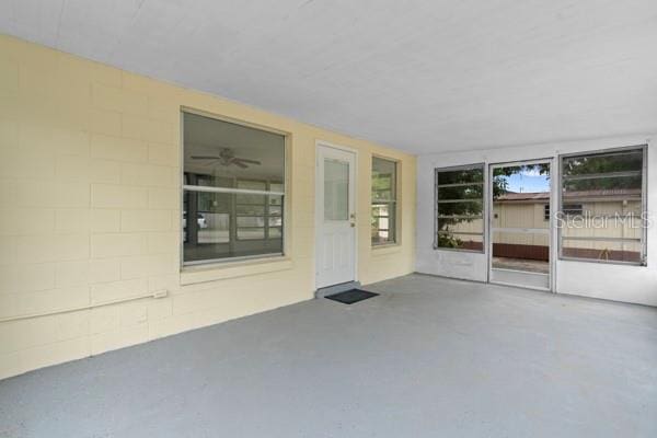 unfurnished sunroom featuring ceiling fan