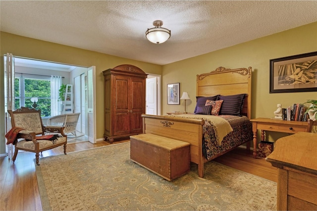 bedroom featuring light hardwood / wood-style floors and a textured ceiling