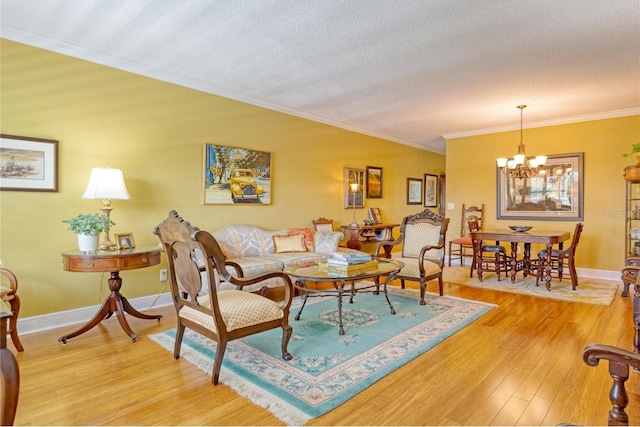 living room featuring ornamental molding, a notable chandelier, light hardwood / wood-style flooring, and a textured ceiling