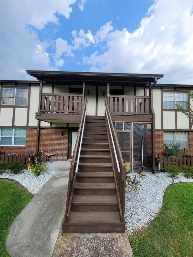 back of property with stairs and brick siding