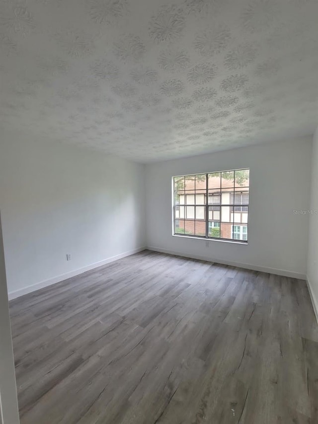 empty room featuring a textured ceiling and hardwood / wood-style floors