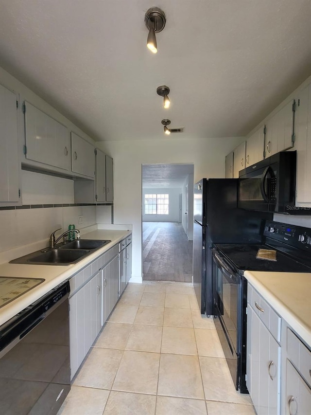 kitchen featuring gray cabinets, black appliances, light hardwood / wood-style flooring, and sink