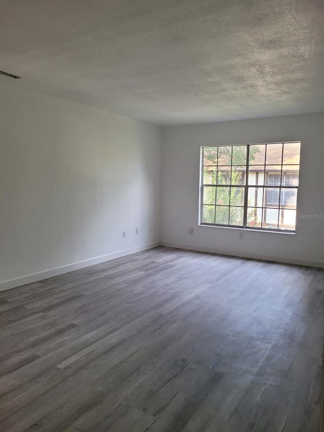 spare room with wood-type flooring and a textured ceiling