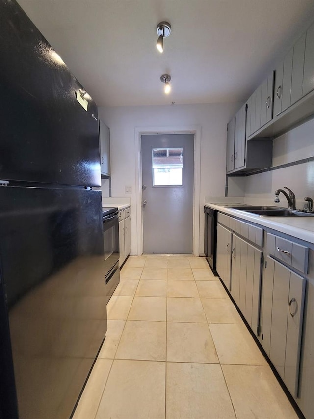 kitchen with sink, black appliances, gray cabinets, and light tile patterned floors